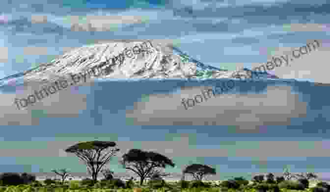 A Breathtaking View Of The Summit Of Mount Kilimanjaro, With Its Iconic Snow Capped Peak Piercing The Clouds. In The Dust Of Kilimanjaro (A Shearwater Book)