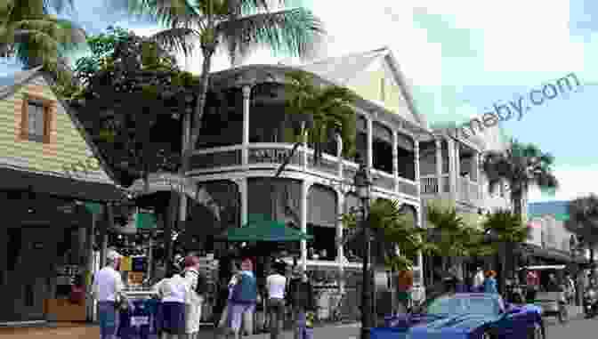 A Bustling Duval Street In Key West, Lined With Historic Buildings And Shops. KEY WEST: See It Before It Sinks